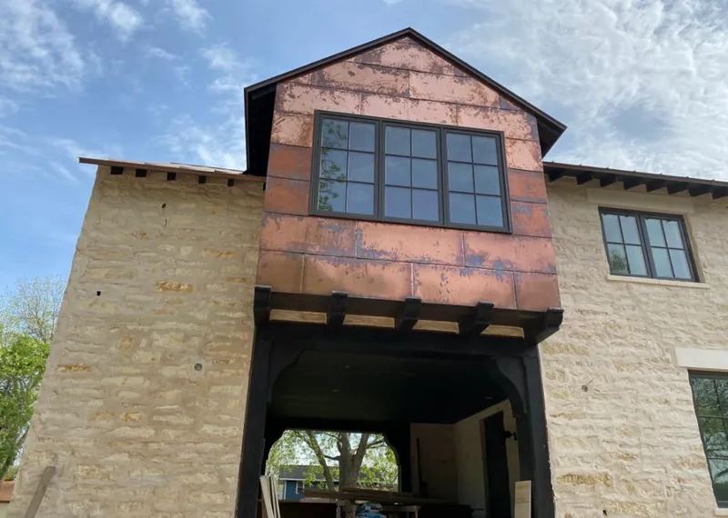 Copper metal panel facade on a stone building for Metal Roof Coating in Carolina Shores